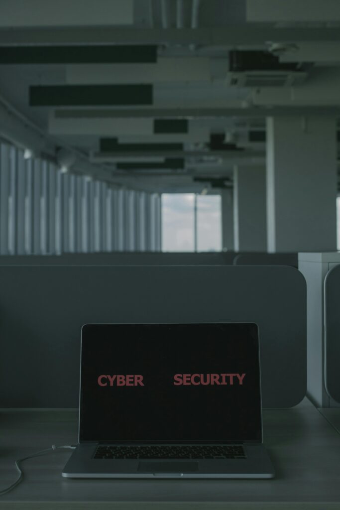 Laptop displaying 'Cyber Security' in a modern office setting, emphasizing tech and cybersecurity themes.