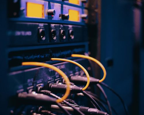 Close-up of network cables and ports in a server rack, showcasing connectivity.